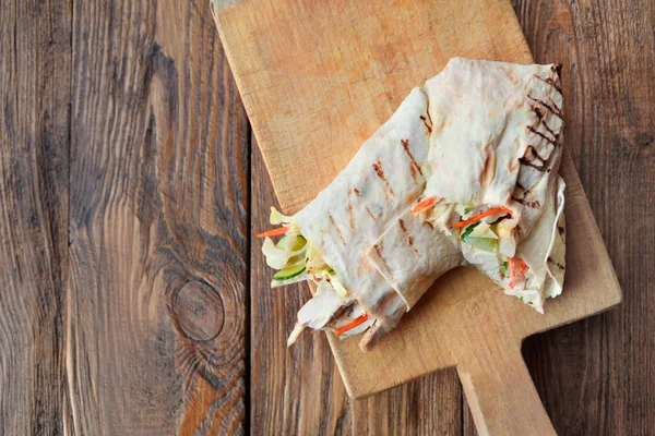 Burrito mit Fleisch und Gemüse auf Holz, von oben — Stockfoto