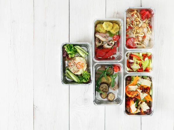 Healthy food take away in boxes, top view at wood