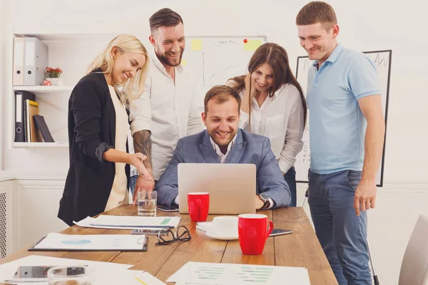 Gente de negocios feliz equipo junto con el ordenador portátil en la oficina — Foto de Stock