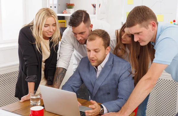 Happy business people team together near laptop in office