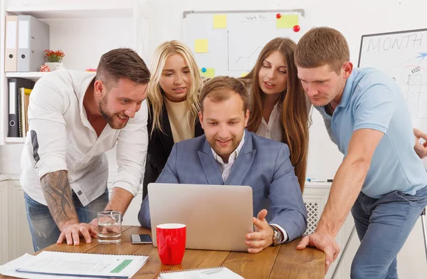 Happy business people team together near laptop in office