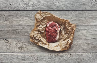 Ham sığır eti biftek koyu ahşap masa arka planda, üstten görünüm