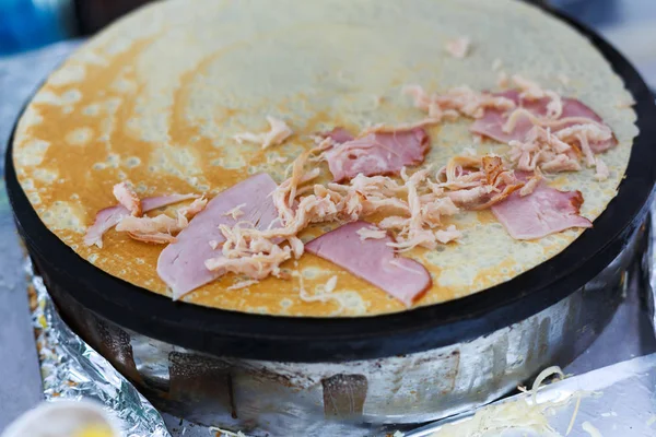 Vendor making crepe with ham outdoors — Stock Photo, Image