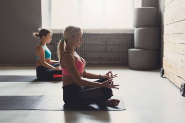 Yoga sınıfındaki genç kadın meditasyon poz rahatla