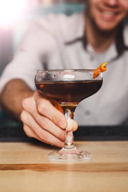 Genç barmen gece kulübü barda kokteylin alkol sunar