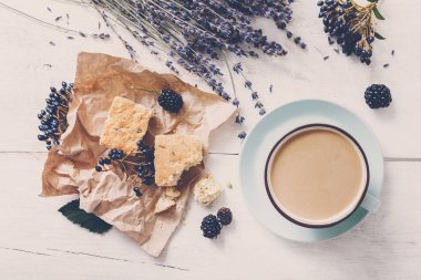 Beyaz ahşap üzerine sütlü kahve ve çiçek kompozisyon