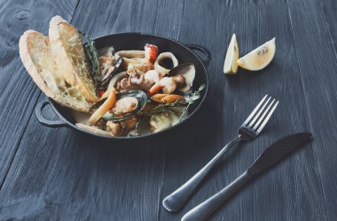 Deniz ürünleri güveç tencerede koyu ahşap arka plan üzerinde