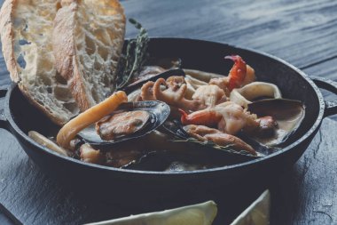 Deniz ürünleri güveç tencerede koyu ahşap arka plan üzerinde