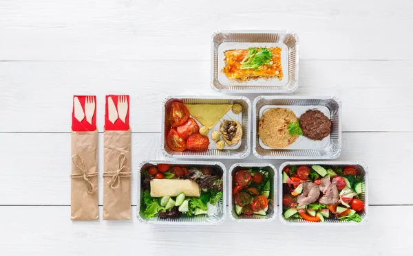 Healthy food take away in boxes, top view at wood