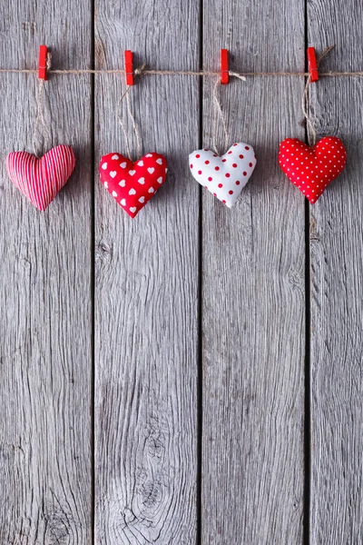 Valentine day background, pillow hearts border on wood, copy space