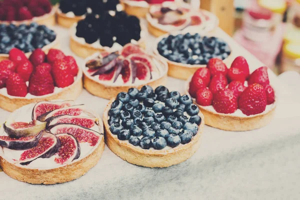 Fruit and berry tarts dessert tray assorted outdoors