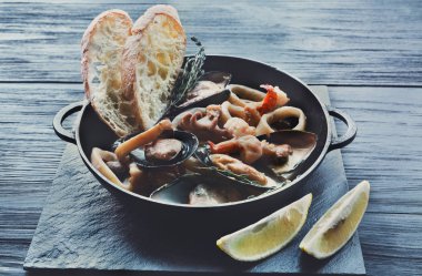 Deniz ürünleri güveç tencerede koyu ahşap arka plan üzerinde