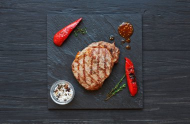 Izgara dana biftek koyu ahşap masa arka planda, üstten görünüm