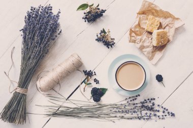 Beyaz ahşap üzerine sütlü kahve ve çiçek kompozisyon