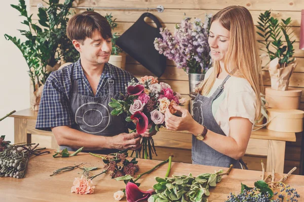 Floristería y asistente en la entrega de la tienda de flores hacer ramo de rosas —  Fotos de Stock