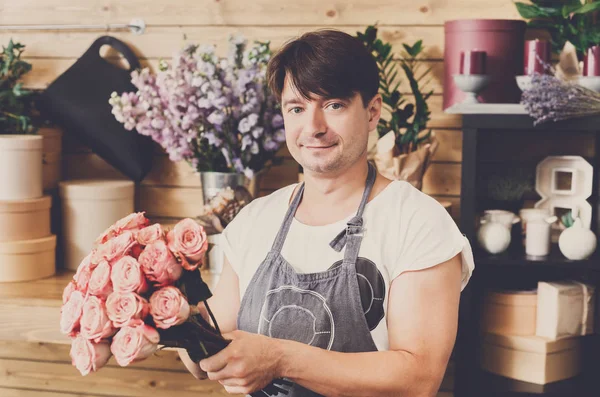Asystent mężczyzna w kwiaty sklep dostawa bukiet róż — Zdjęcie stockowe