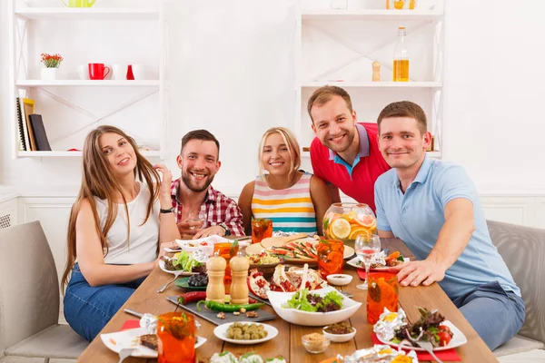 Group of happy young people at dinner table, friends party — Stock Photo, Image