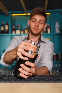 Genç yakışıklı barmen içinde Bar sallayarak ve alkol kokteyl karışımı