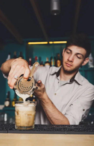 Молодые бармены делают коктейли, наливают сироп в стекло — стоковое фото