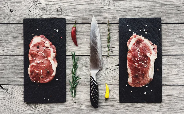 Raw beef steaks on dark wooden table background, top view — Stock Photo, Image