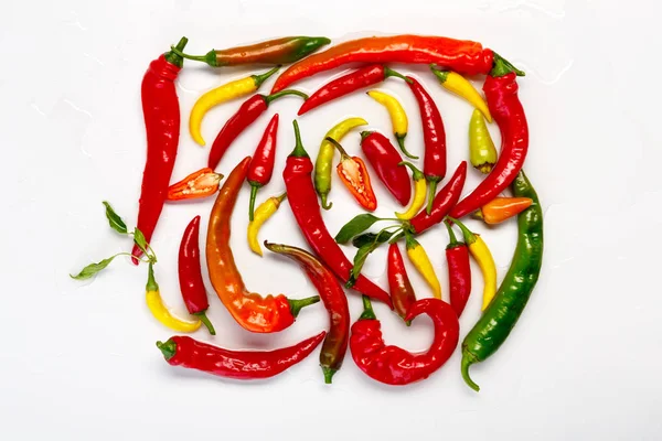 Beyaz arka plan üzerinde izole yeşil, sarı ve kırmızı pul biber
