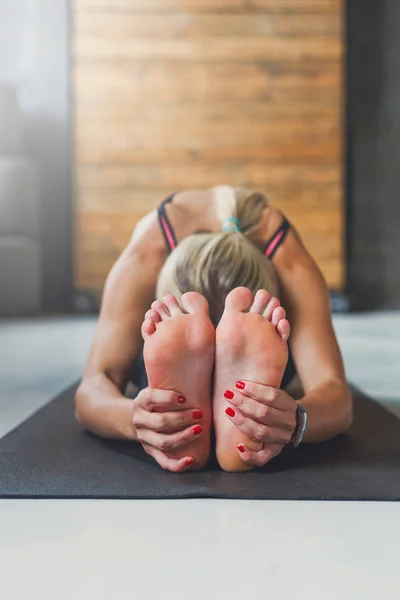 Donna fa posa yoga in classe, sedersi in avanti curva asana — Foto Stock