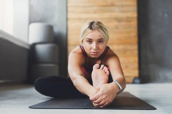 Woman makes yoga pose in class, sit forward bend asana — Stock Photo, Image