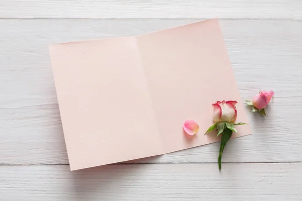 Fondo de San Valentín, flores de rosas y tarjeta en madera blanca — Foto de Stock