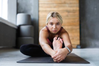 Kadın sınıfta poz, ileriye doğru viraj asana oturup yoga yapar