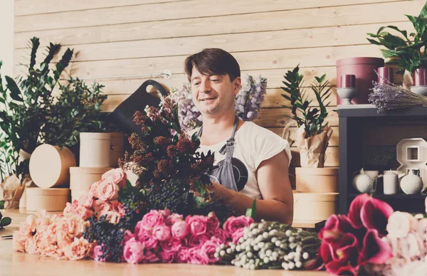 Hombre asistente en la entrega de la tienda de flores hacer ramo —  Fotos de Stock