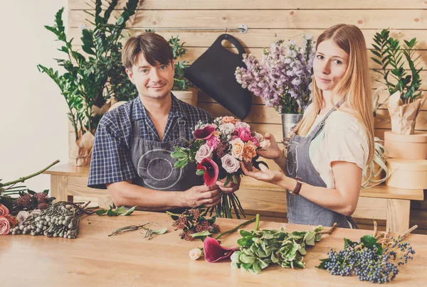 Floristería y asistente en la entrega de la tienda de flores hacer ramo de rosas —  Fotos de Stock