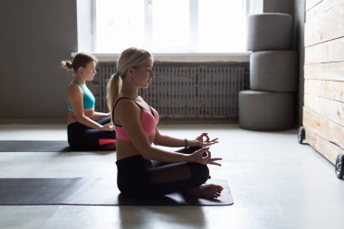 Yoga sınıfındaki genç kadın meditasyon poz rahatla
