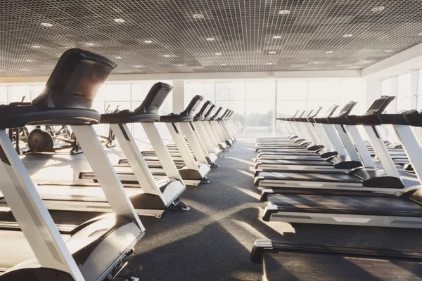 Modern gym interior with equipment, treadmills for fitness cardio training