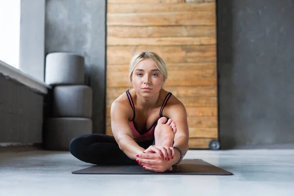 Woman makes yoga pose in class, sit forward bend asana — Stock Photo, Image