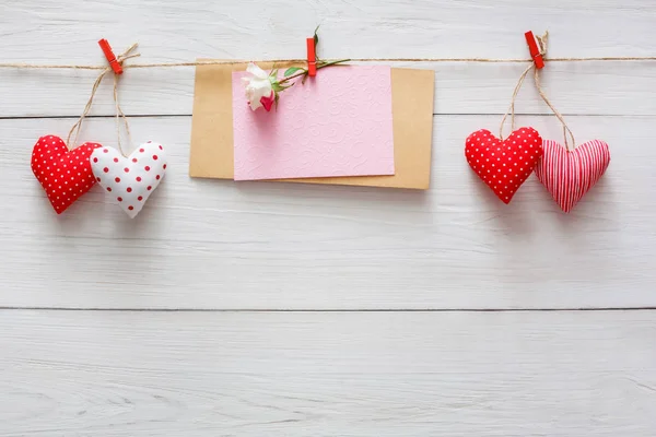 Valentine dag achtergrond, kussen harten en kaart op hout — Stockfoto