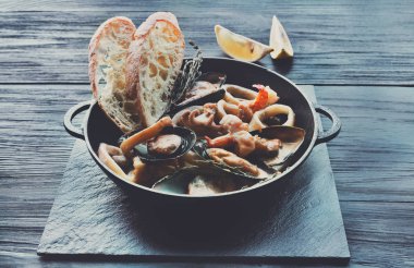 Deniz ürünleri güveç tencerede koyu ahşap arka plan üzerinde