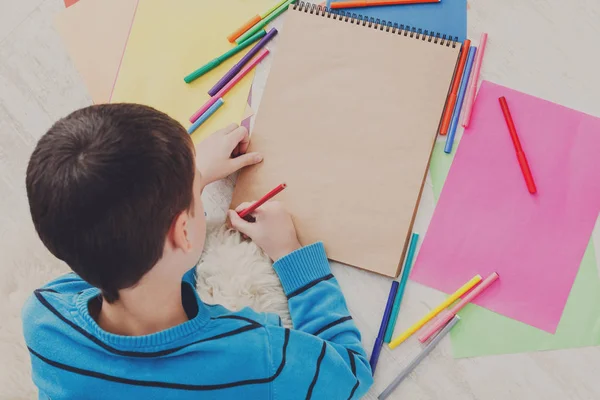 Chico dibujo con lápices de colores y — Foto de Stock