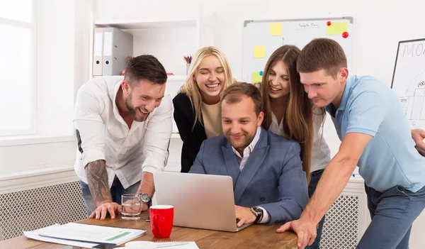 Zespół osób szczęśliwy business razem spojrzeć na laptopa w biurze — Zdjęcie stockowe