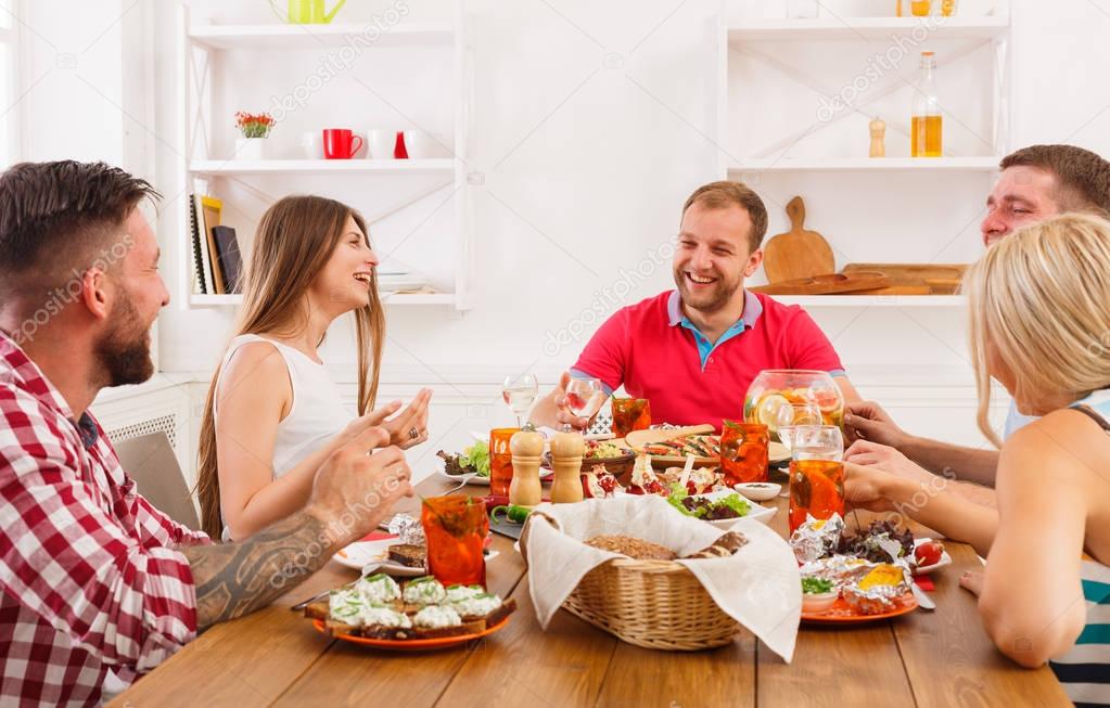 Group of happy people at festive table dinner party