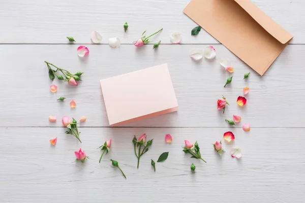 Valentine dag achtergrond, papieren kaart en bloemen op wit hout — Stockfoto
