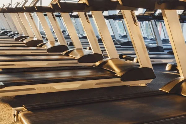 Interior moderno ginásio com equipamentos, esteiras para treinamento de cardio fitness — Fotografia de Stock