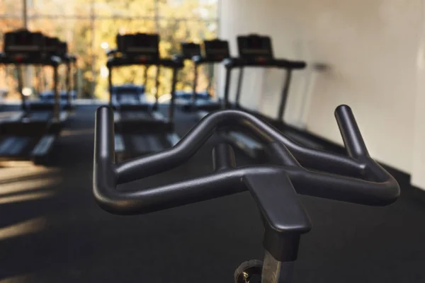 Interior moderno do ginásio com equipamento, guiador de bicicleta de exercício de fitness — Fotografia de Stock