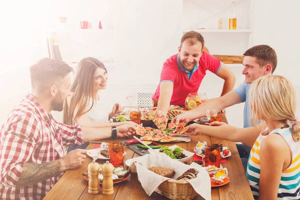 Lidé jedí pizzu na sváteční stůl večerní párty — Stock fotografie