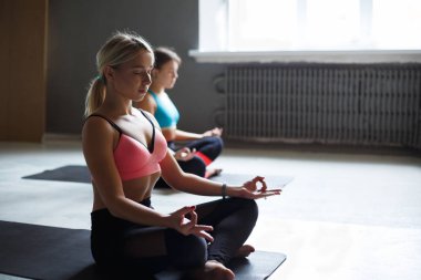 Yoga sınıfındaki genç kadın meditasyon poz rahatla