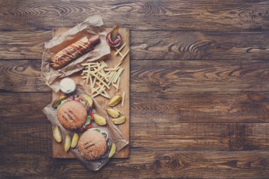 Fast food yukarıdan ahşap üzerine. Hamburger, sosisli ve patates