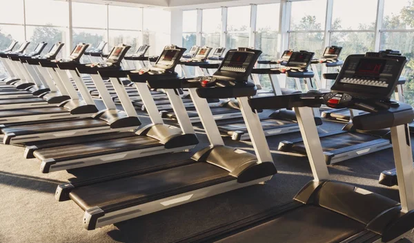 Interior moderno ginásio com equipamentos, esteiras para treinamento de cardio fitness — Fotografia de Stock
