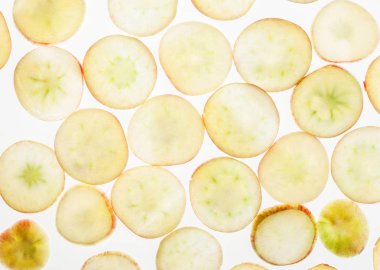 Arkadan aydınlatmalı ince dilim sarı elma, soyut dokulu arka plan