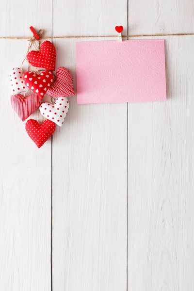 Fondo de San Valentín, corazones de almohada y tarjeta en madera — Foto de Stock