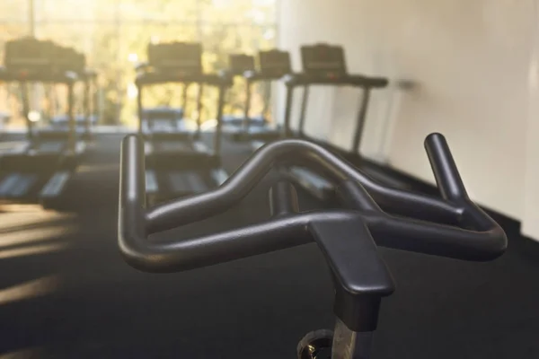 Modern gym interior with equipment, fitness exercise bike handlebar — Stock Photo, Image