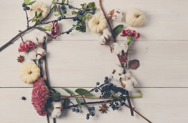 Blumenrahmen aus getrockneten Blumen auf weißem Holz, Draufsicht. — Stockfoto